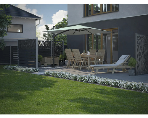 Gartenszene mit Esstisch, Stühlen, Sonnenschirm, Liegestuhl und Sichtschutzwänden auf einer Terrasse neben einem Rasen