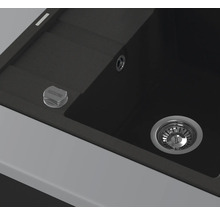 Detailansicht einer schwarzen Küchenspüle mit Abfluss und Bedienknopf