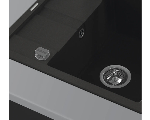 Detailansicht einer schwarzen Küchenspüle mit Abfluss und Bedienknopf