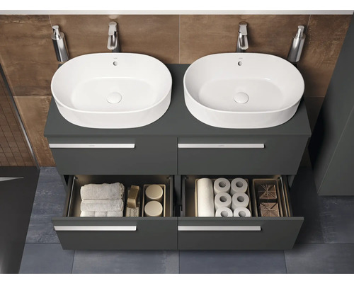 Badezimmer mit zwei Waschbecken auf einem grauen Unterschrank mit offenen Schubladen, in denen Handtücher und Toilettenpapier liegen