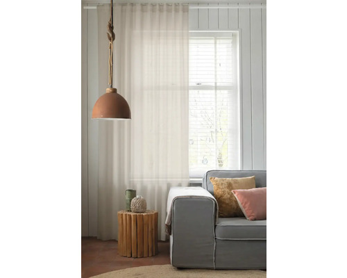 Wohnzimmer mit Vorhang, Lampe und Sofa für eine helle und freundliche Atmosphäre.