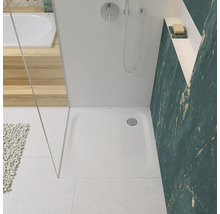Badezimmer mit Dusche, Duschwanne, Armatur und gefliester Wand