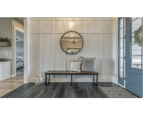 Eingangsbereich mit Spiegel, Bank und dekorativen Kissen an der Wand