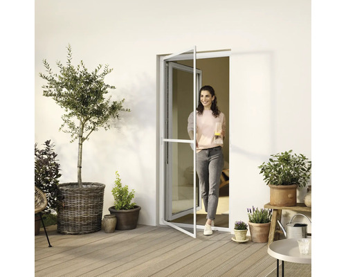 Frau betritt Terrasse durch Insektenschutztür