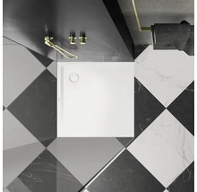 Badezimmer mit quadratischer, weißer Duschwanne und schwarz-weißem Schachbrettmuster auf dem Boden.