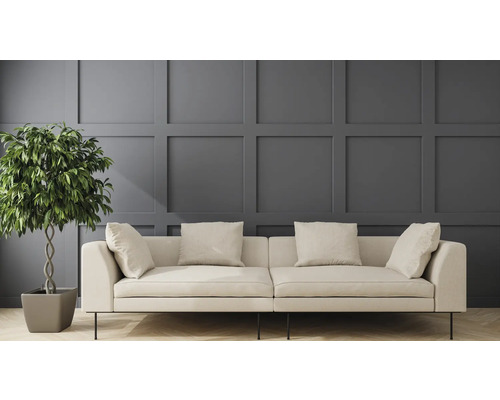 Helles Sofa mit Kissen und Zimmerpflanze vor einer Wandpaneele