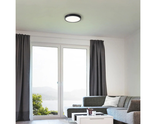 Wohnzimmer mit Deckenleuchte und grossen Fenstern