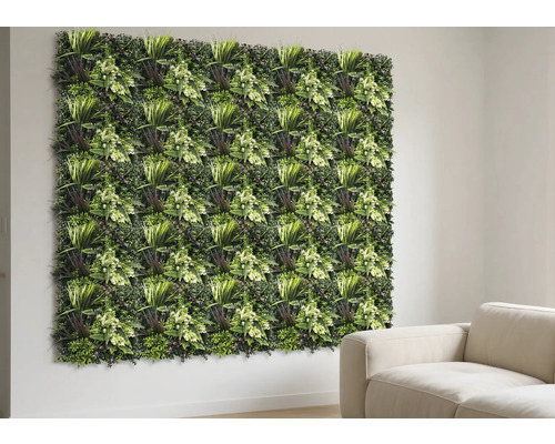 Künstliche Pflanzenwand Thallo 38 x 38 cm Wand mit grünen Pflanzenpaneelen und Dekoration neben einem beigen Sofa