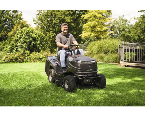 Mann fährt mit einem AL-KO Aufsitzmäher über eine Rasenfläche.
