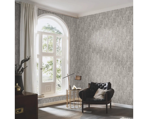 Wohnzimmer mit gemusterter Tapete, Sessel und Fenster