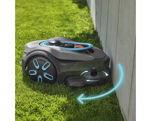 Rasenmähroboter beim Mähen entlang einer Wand auf Gras