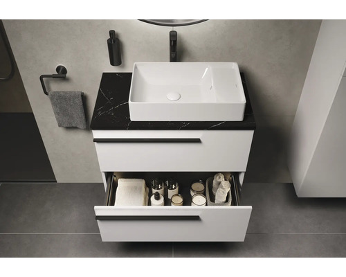 Modernes Badezimmer mit weißem Waschtisch, schwarzer Marmorplatte und offenem Schubladeninhalt