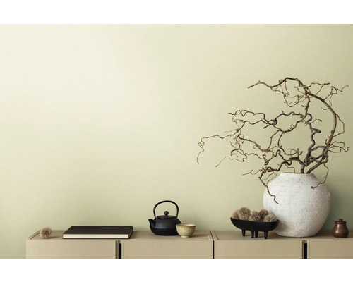 Dekorative Szene mit Teekanne, Buch und Zweigen in Vase auf einem Sideboard