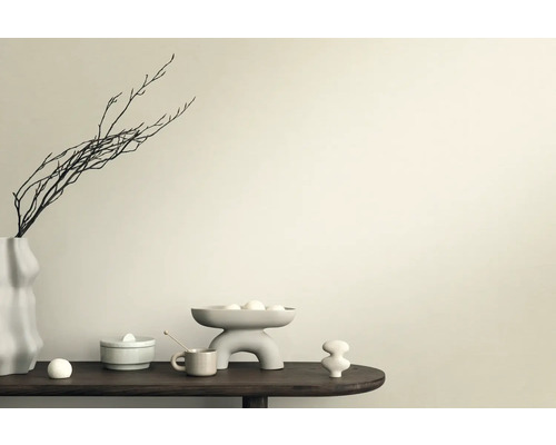 Dekorative Szene mit Vase, Ästen, Schale und Keramikfiguren auf einem Tisch