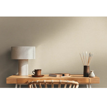 Szene mit Schreibtisch, Lampe und Malutensilien vor einer Wand