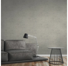 Graue Sofagarnitur mit Stehlampe und Beistelltisch vor einer grauen Wand