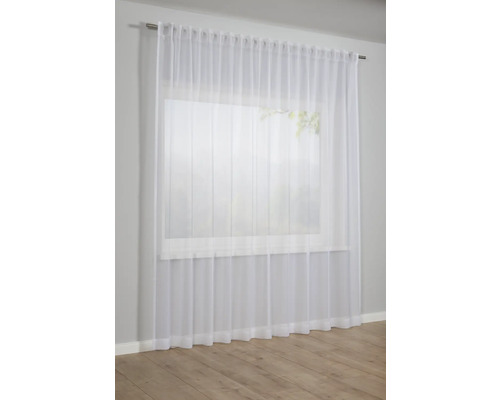 Transparenter, weisser Gardinenschal vor einem Fenster.