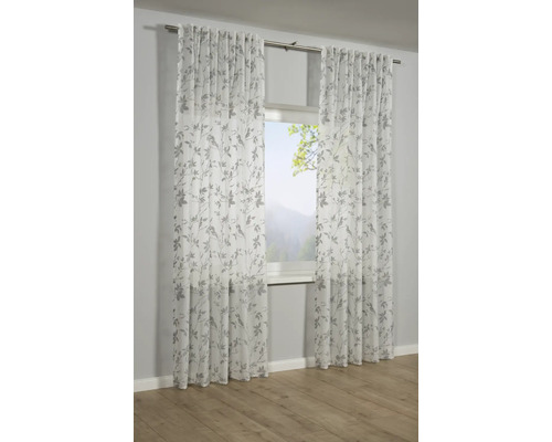 Zwei transparente Gardinen mit Blätterdessin vor einem Fenster