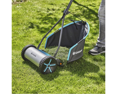 Handrasenmäher auf Rasenfläche mit Grasfangkorb