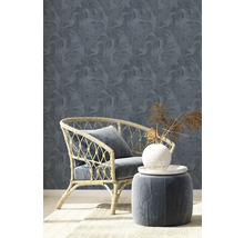 Szene mit Rattan-Sessel, Hocker und floral gemusterter Tapete