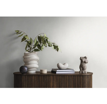 Dekoratives Interieur mit schlankem Holzschrank, Vase mit Pflanzen, Skulptur und Büchern für eine stilvolle Raumatmosphäre.