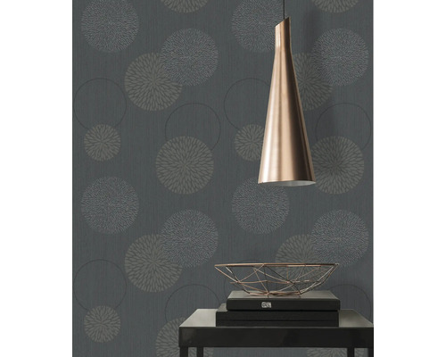 Nahaufnahme einer Wand mit floral gemusterter Tapete, einer Lampe und einem Tisch