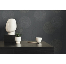 Einrichtungsgegenstände vor grauer Tapete mit kreisförmigem Muster