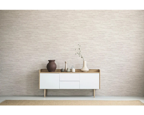 Wohnzimmer mit Kommode, Vasen und dekorativen Objekten vor einer gemusterten Wand