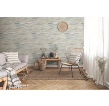 Wohnzimmer mit gemusterter Tapete, Sofa und Sessel auf einem Teppich