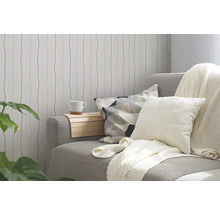 Wohnzimmer mit gemusterter Tapete, Sofa, Kissen und Beistelltisch