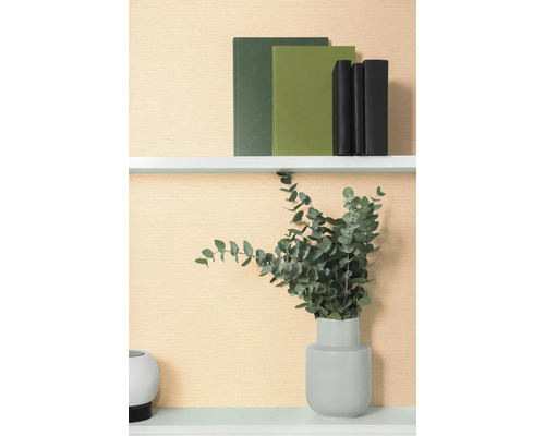 Dekoratives Regal mit Büchern und Eukalyptus in Vase.