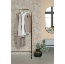 Kleiderständer mit Kleidung, Spiegel und Dekoration in einem Raum.