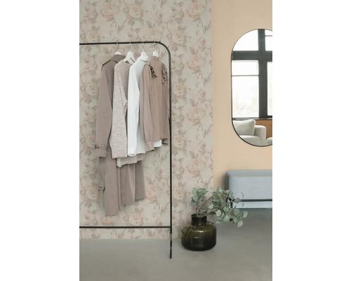 Kleiderständer mit Kleidung, Spiegel und Dekoration in einem Raum.