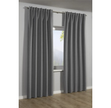 Graue Gardinen vor einem Fenster mit Blick auf eine Berglandschaft.