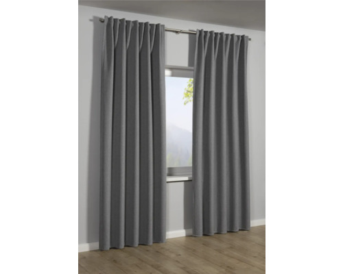 Graue Gardinen vor einem Fenster mit Blick auf eine Berglandschaft.