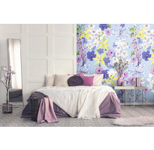 Schlafzimmer mit Doppelbett, Spiegel, Nachttisch und floraler Tapete