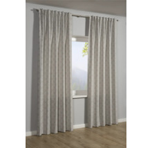 Zwei gemusterte Gardinenschals hängen vor einem Fenster.