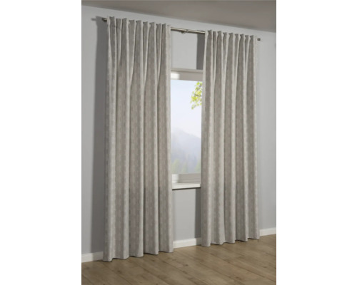 Zwei gemusterte Gardinenschals hängen vor einem Fenster.