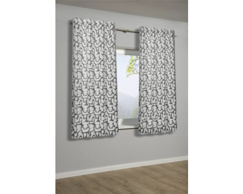 Zwei gemusterte Gardinenschals hängen vor einem Fenster