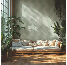 Heller Raum mit Palettensofa, Kissen und Zimmerpflanzen