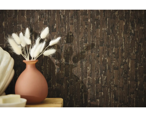 Dekorative Wandgestaltung mit einer Tapete in Steinoptik und einer Vase mit Ziergras