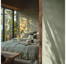 Schlafzimmer mit Bettwäsche, Kissen, Getränk und natürlichem Licht