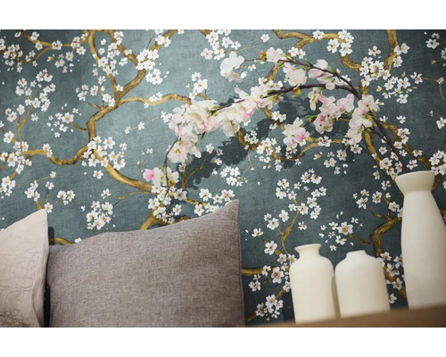 Detailaufnahme einer Wand mit Blumentapete, Kissen und dekorativen Vasen.