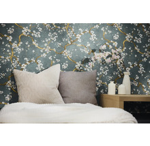 Dekoratives Schlafzimmer mit einer Wandtapete mit Blumenmuster, Kissen und Vasen