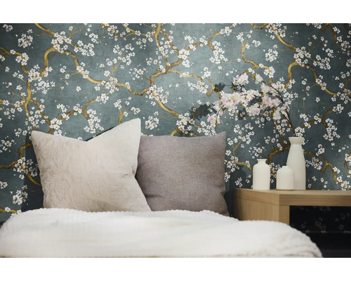 Dekoratives Schlafzimmer mit einer Wandtapete mit Blumenmuster, Kissen und Vasen