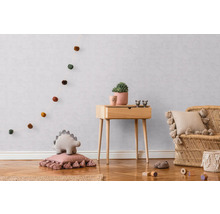 Kinderzimmer mit Holzkommode, Rattansessel und dekorativen Accessoires