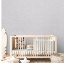 Babyzimmer mit Gitterbett, Teddybär und Kissen
