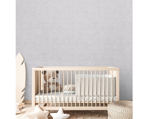 Babyzimmer mit Gitterbett, Teddybär und Kissen