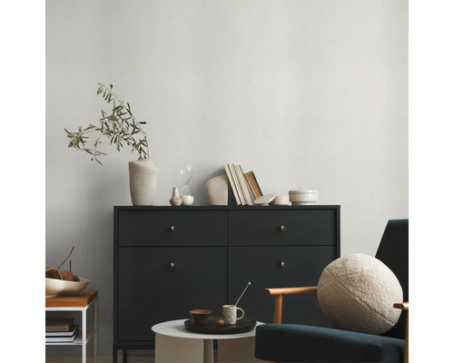 Wohnzimmer mit schwarzer Kommode, Dekoration und Sitzgelegenheit