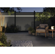 Moderne Gartenszene mit Zaun, Beleuchtung und Sitzbereich für entspannte Abende